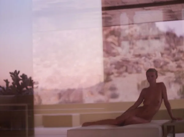 Mona Kuhn photograph of a softly lit figure in a muted interior, partially obscured by shadow, creating a quiet, dreamlike atmosphere.