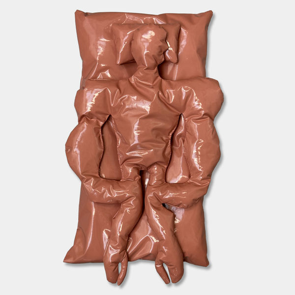 Flesh-toned vinyl sculpture from Joe Madeira’s Figure in Between (2024), showing a padded, reclining human form that explores posthuman embodiment, soft sculpture, and contemporary materiality.