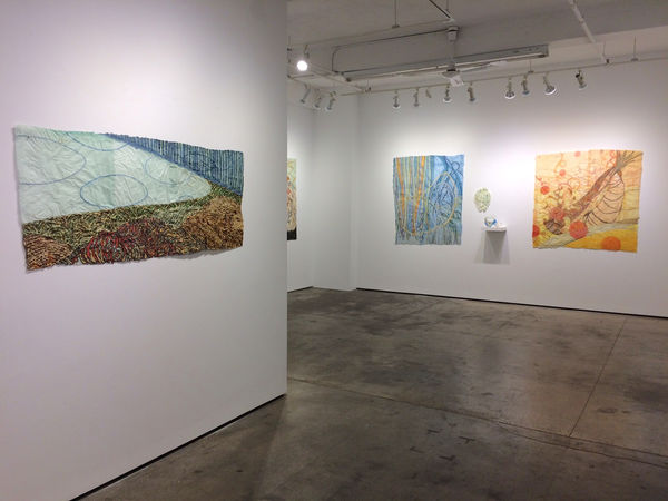 Installation shot of four different works by Nancy Cohen. A small part of another work can also be seen.