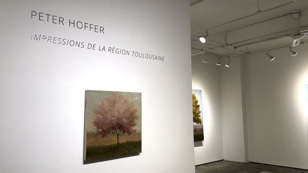 Landscape painting of tree with pink leaves by Peter Hoffer on gallery wall