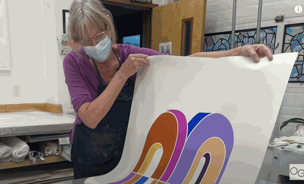 Picture of women holding up painting