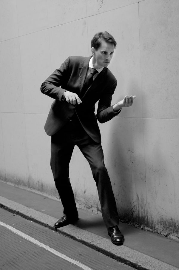 Beware 1, Spud, a portrait of man in suit with hands looking like holding the arms, but the hands are empty, the pose like a soldier, photography portrait print by Brian Griffin, at MMX Gallery