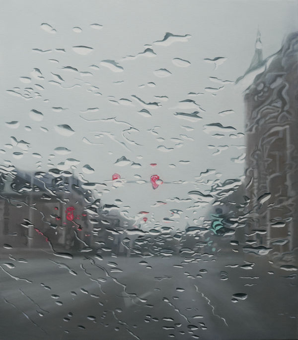 An out of focus view of a road with buildings on either side through a window covered in water droplets by artist Esther Nienhuis.