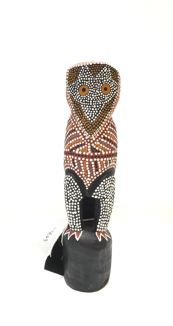 A sculpture made of carved wood in the shape of bird, decorated with lines and dots by artist Judy Manany.