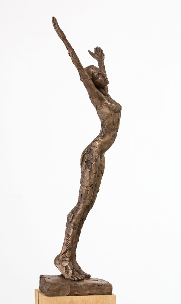 Carol Peace sculpture of a female figure stretching her arms and body up, with her eyes closed and leaning slightly forward.