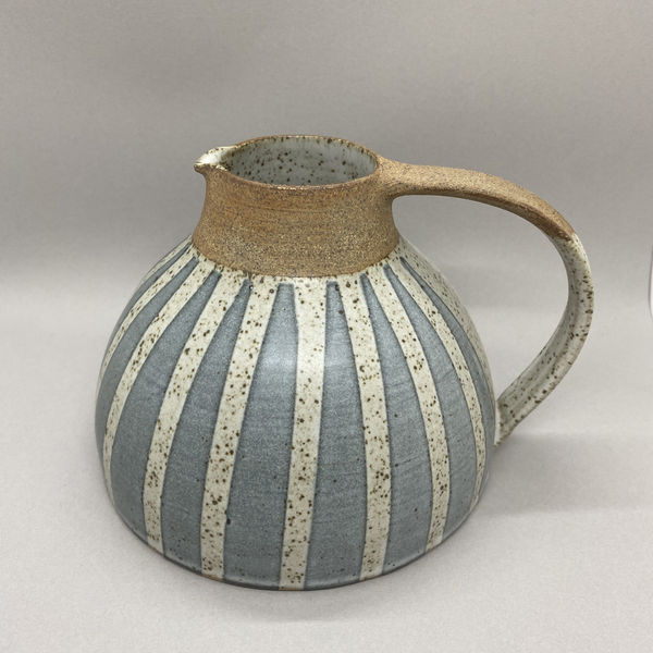 Kate Garwood jug in a squat, round shape, brown at the top with a blue body and white vertical stripes