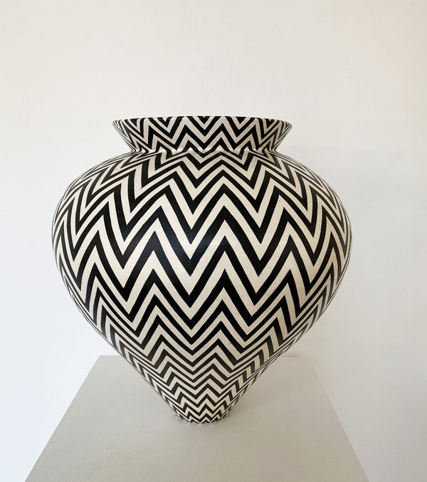 Ant & Di Edmonds - Tydd Pottery wide, heart shaped ceramic black and white vessel with a horizontal zig zag pattern.