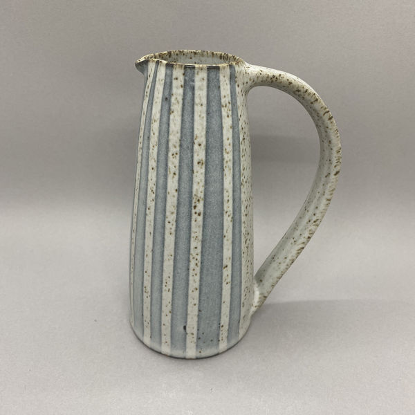 Kate Garwood narrow jug in a straight shape with a white glaze and blue stripes.