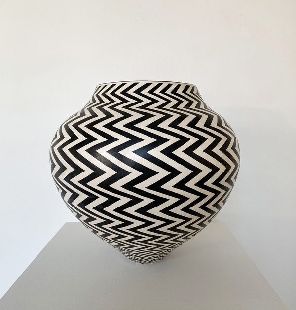 Ant & Di Edmonds - Tydd Pottery wide, heart shaped ceramic black and white vessel with a vertical zig zag pattern.
