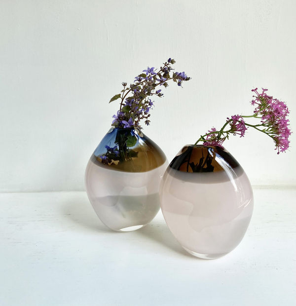 Michele Oberdieck Two small round glass vessels in milky white and mossy brown.