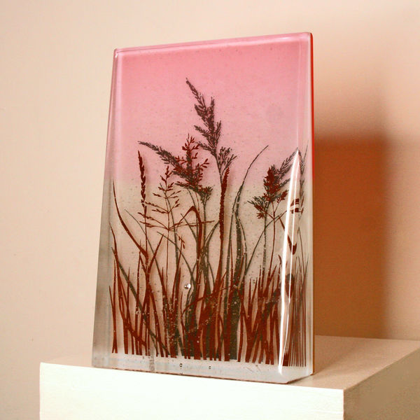 Helen Slater standalone glass sculpture with drawings of a row of grasses cast in light orange and opaline glass