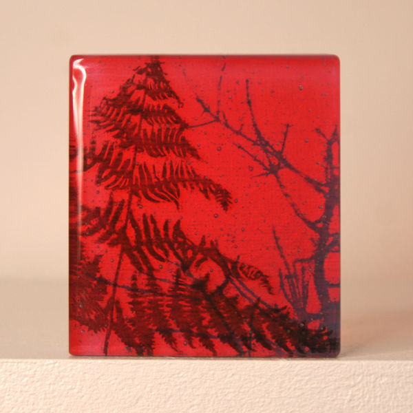 Helen Slater glass sculpture with black drawing of fern in coral and opaline glass