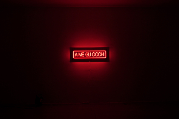 A hand-blown and hand-folded neon lettering, mounted on Dibond that reads "A me gli occhi".