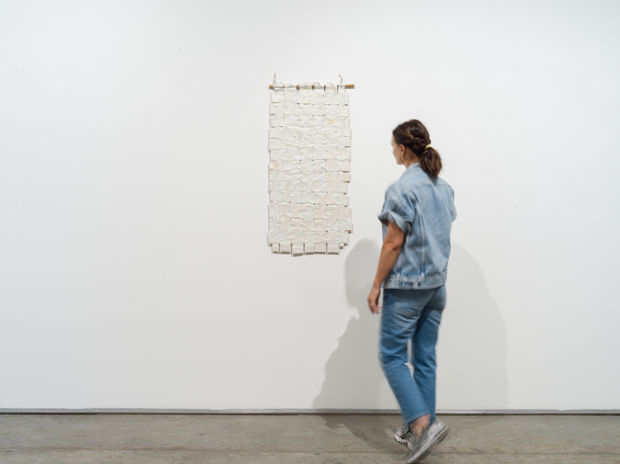 Titanium White No. 2 (2014) is composed of woven canvas strips that Sharif paints over, suspends, and binds using a...