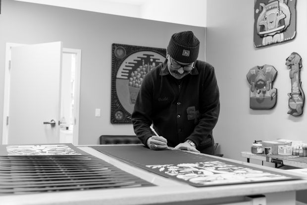 Black and White Photo of Jeremy Fish signing prints