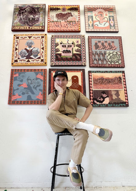 Portrait of Keya Tama sitting in front of his collaborative paintings