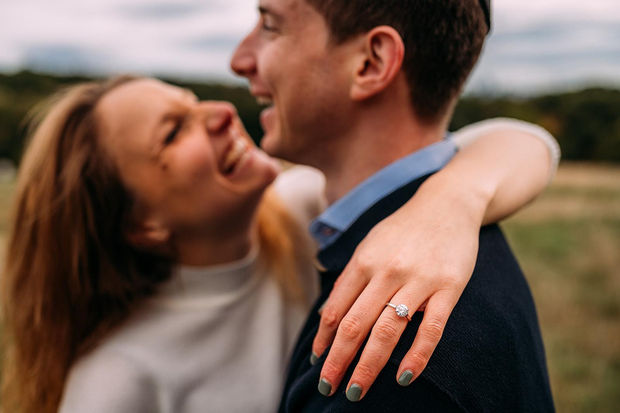 Happy engaged couple celebrating with a bespoke engagement ring from Aril Jewels.