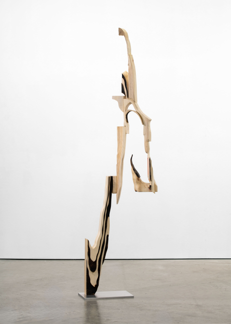 A freestanding sculpture by David Armstrong Six made of wood carved into an abstracted geometric form.
