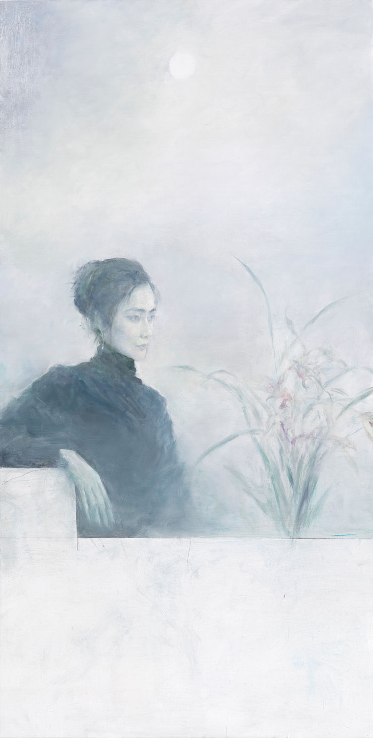 A young lady in black cloth sits on a white chair looking towards the right and viewing the flowers