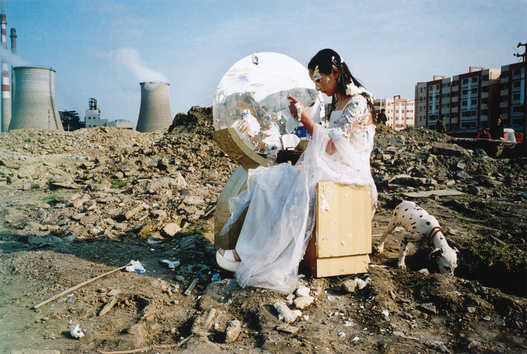 A fair maiden in white long skirt sits in front of a dressing table on the ruins