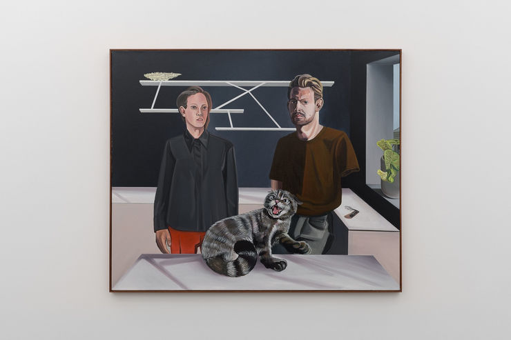 Two men and a grey cat on a kitchen counter in a painting by Alan Stanners