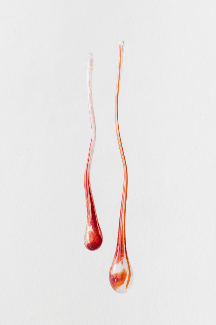 Isabella Séville Fürnkäs The Desiring Machines, 2025 A pair of individual mouth-blown red ruby glass drops, ethanol, engraved words. left: 64cm, Ø 20cm. right: 83cm, Ø 26cm.
