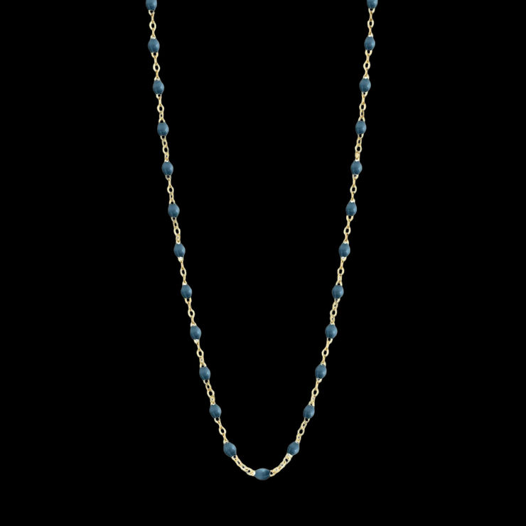 A delicate 18k yellow gold chain necklace featuring evenly spaced small denim blue resin beads, arranged in a gentle U-shape by Fringe Gallery studio jeweler Gigi Clozeau.