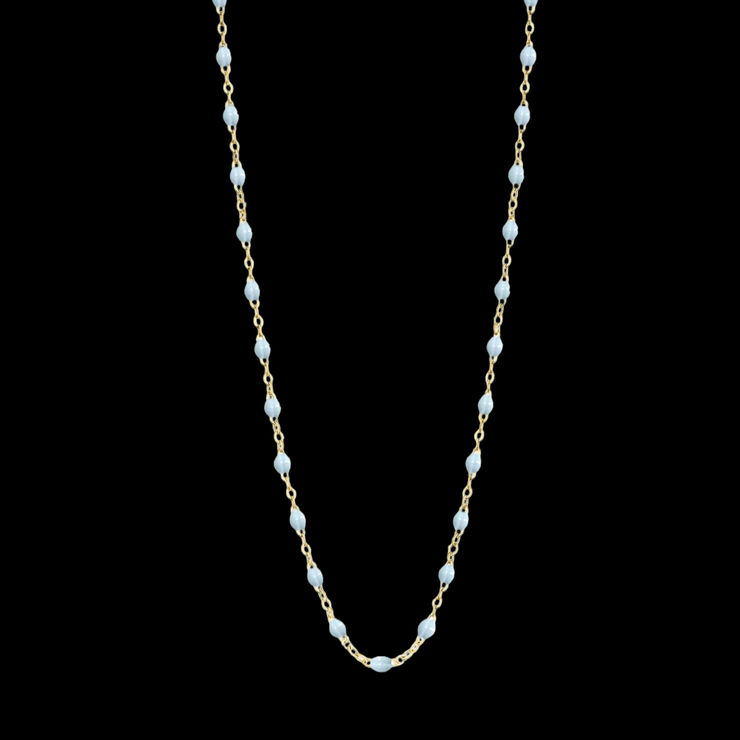 A delicate 18k yellow gold chain necklace featuring evenly spaced small baby blue resin beads, arranged in a gentle U-shape by Fringe Gallery studio jeweler Gigi Clozeau.