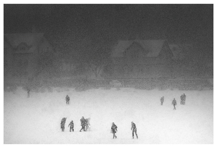 Black and white photograph of people playing on frozen pond in Reykjavik, Iceland during christmas.