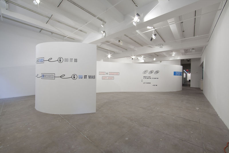 On different curved white walls, various text art has been pasted, reading things like: SO IT IS, and SO IT WAS.