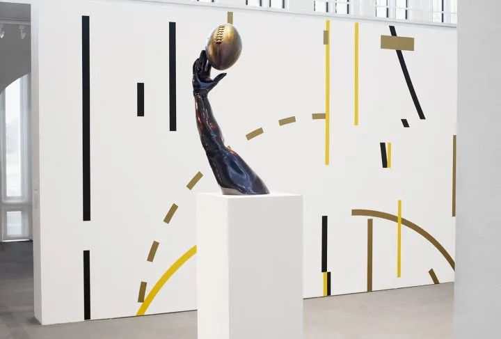 Foreground: Hank Willis Thomas, ”Opportunity” (2015), fiberglass, chameleon auto paint finish (courtesy the artist and Jack Shainman Gallery). Background: Ronny Quevedo,” La Gran Patria (for Alberto Spencer)” (2019), vinyl, 2-panels, 10 x 15 feet each