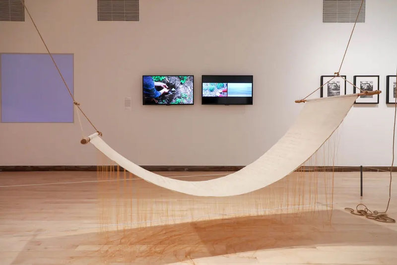 On the wall, from left: Chloë Bass’s “#sky, #nofilter”; Kang Seung Lee’s “Garden”; Laura Aguilar’s photographs. In the foreground is Lee’s “Untitled (List),” 24-karat thread on Sambe, hemp rope, wood. Credit: Will McLaughlin