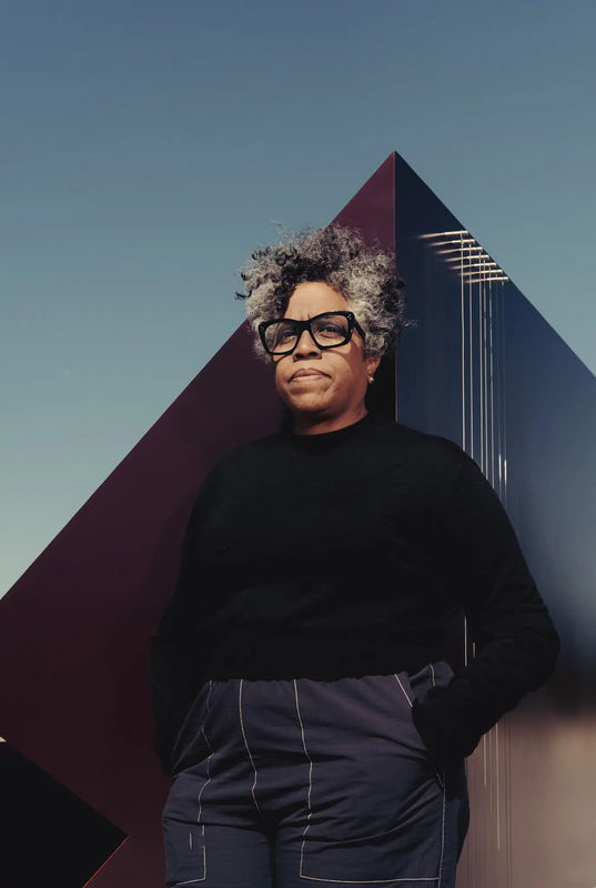 The artist Jennie C. Jones at the Roof Garden of the Metropolitan Museum. The sculptures in her installation include strings that can generate sound in the breeze. Credit...Amir Hamja for The New York Times
