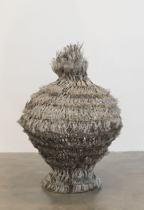 Photo of a Maren Hassinger sculpture made from woven steel wire rope in the shape of a vessel