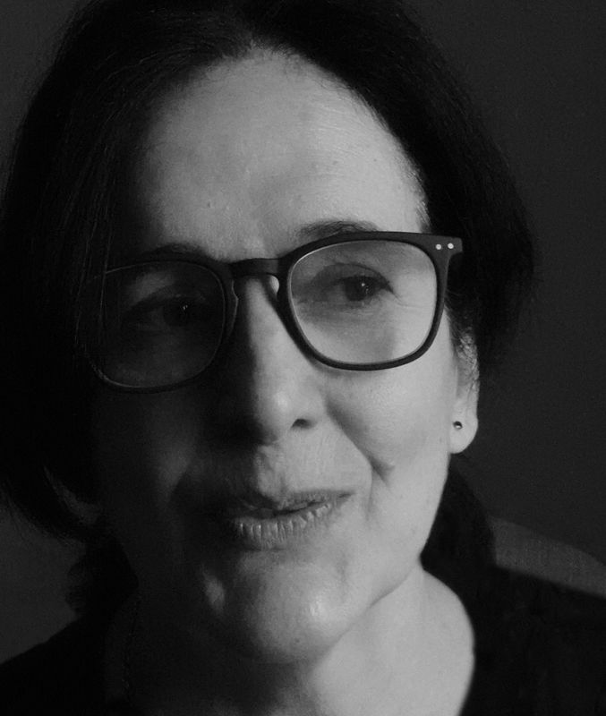 Black-and-white portrait of Beatriz Grau in close-up, wearing glasses and softly illuminated from the side. Her expression is calm and introspective, suggesting a moment of reflection. The image highlights her sensitivity and contemplative presence, quali