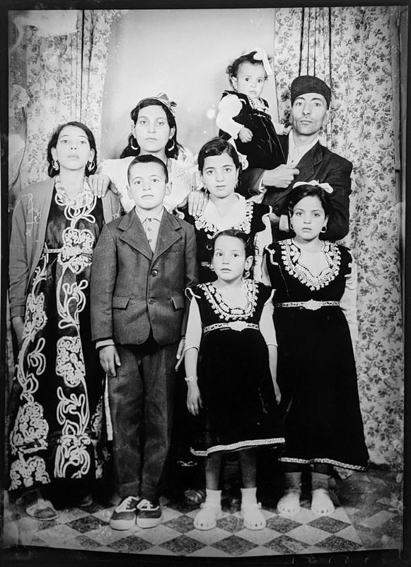 black and white photograph in a photography studio setting of a family