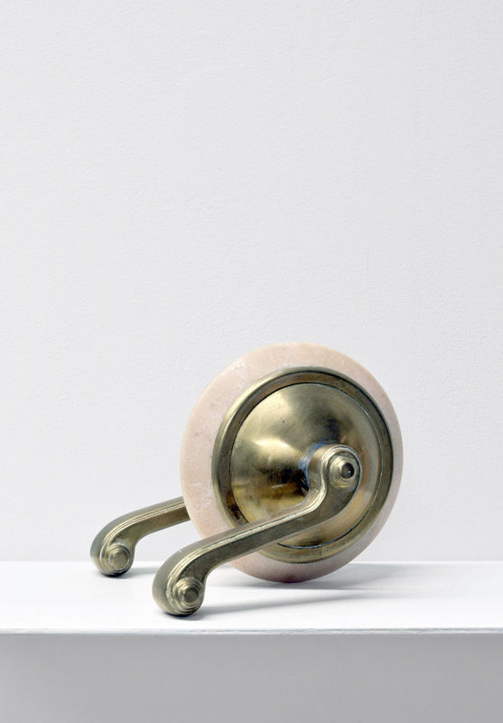 A small minimalist contemporary sculpture with art deco handles and a beige stone
