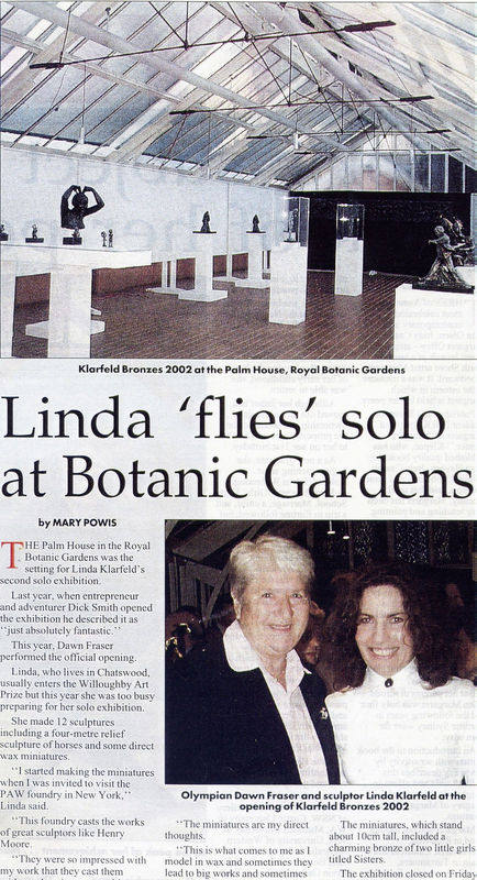 An article titled "Linda 'flies' solo at Botanic Gardens" by Mary Powis, featuring sculptor Linda Klarfeld and Olympian Dawn Fraser at the opening of Klarfeld's 2002 solo exhibition at the Palm House in the Royal Botanic Gardens. The top half of the image