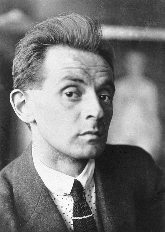 Black and white photograph of Egon Schiele. He is wearing a suit and staring into the camera provocatively.