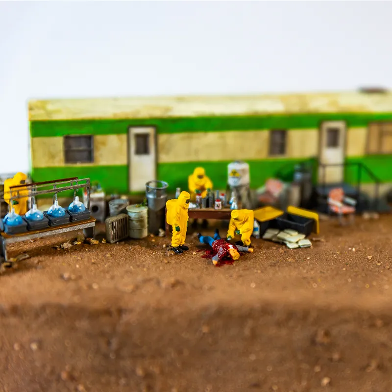 Abigail Goldman diorama of figures in yellow hazmat suits standing over bloody body on ground