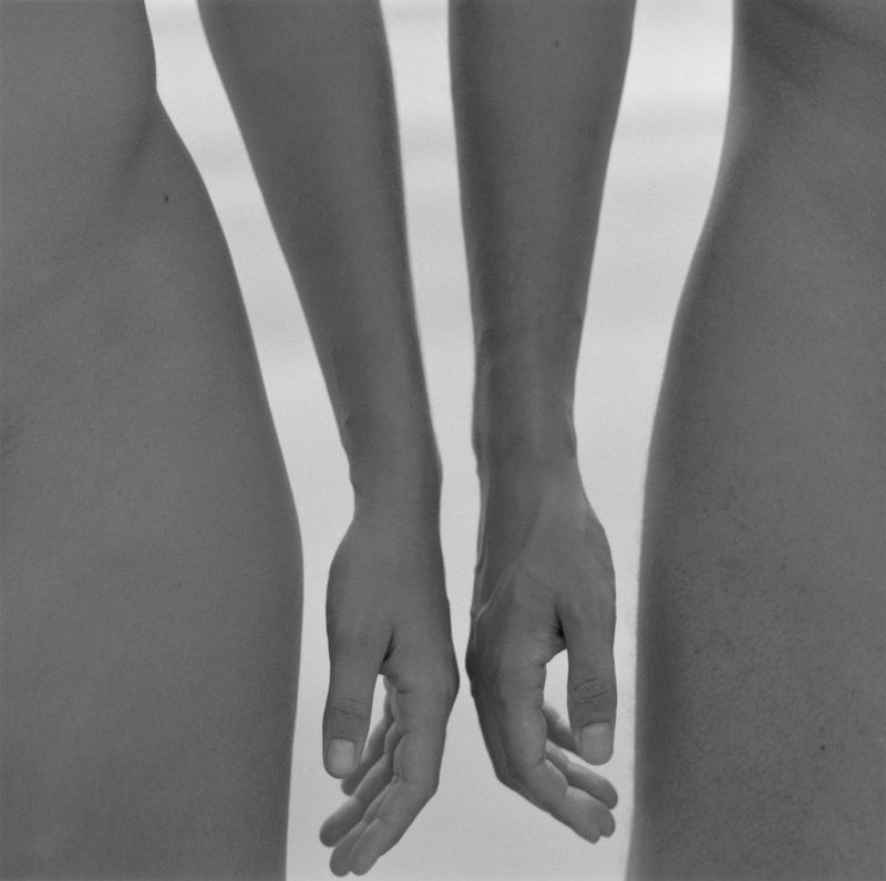 black and white photo of man and woman's hands almost touching