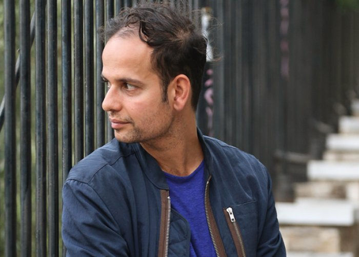 A portrait of Tino Sehgal looking left of camera. 