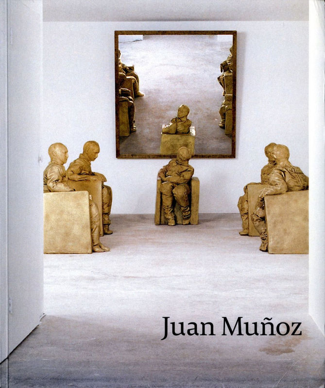 Multiple tan sculptures of five figures sculpted in chairs, one faces towards a mirror positioned behind them and in turn meeting the gaze of the viewer.