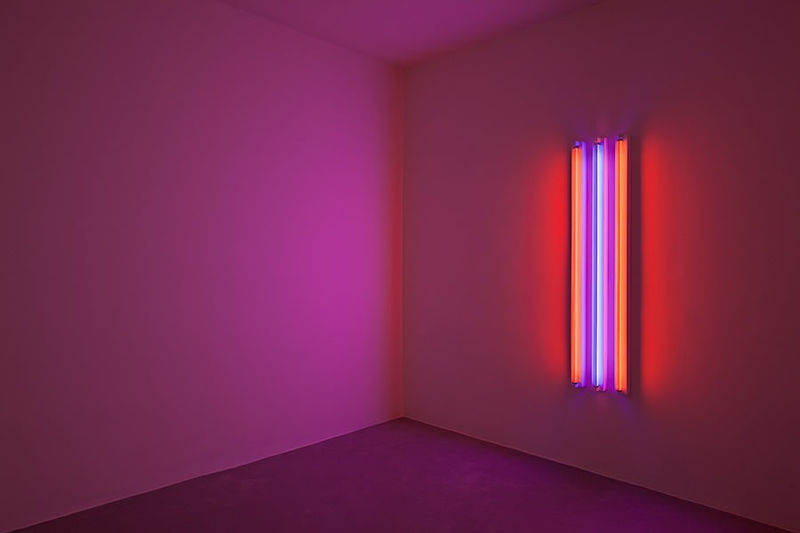 The installation view of Robert Irwin's work shows lines of light in pink, red, and blue hues.
