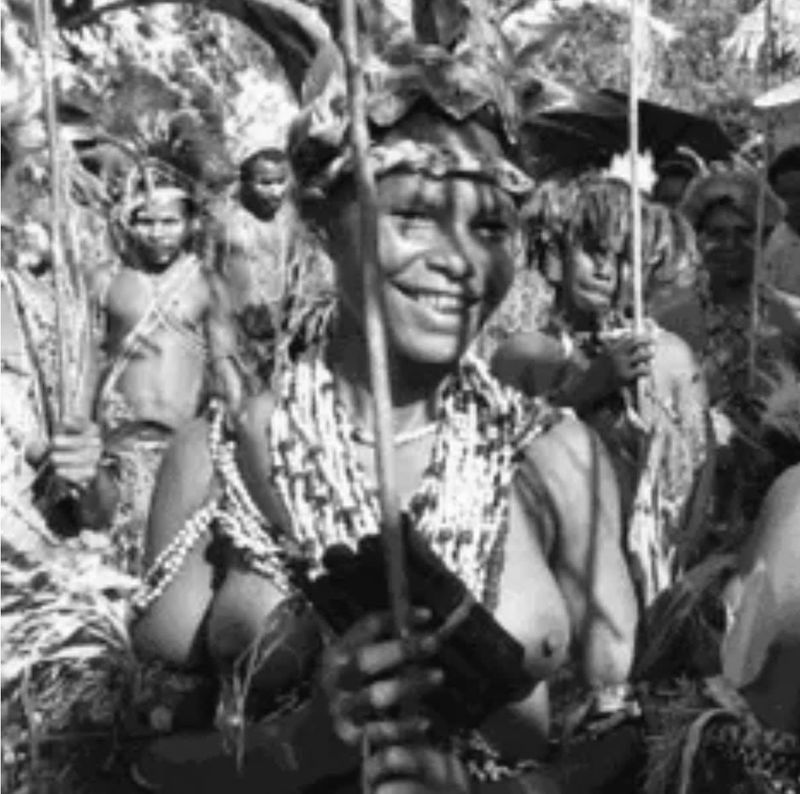 A black and white photograph of Papa New Guinean artist Ilma Ugiobari (Savari) wearing traditional adornments