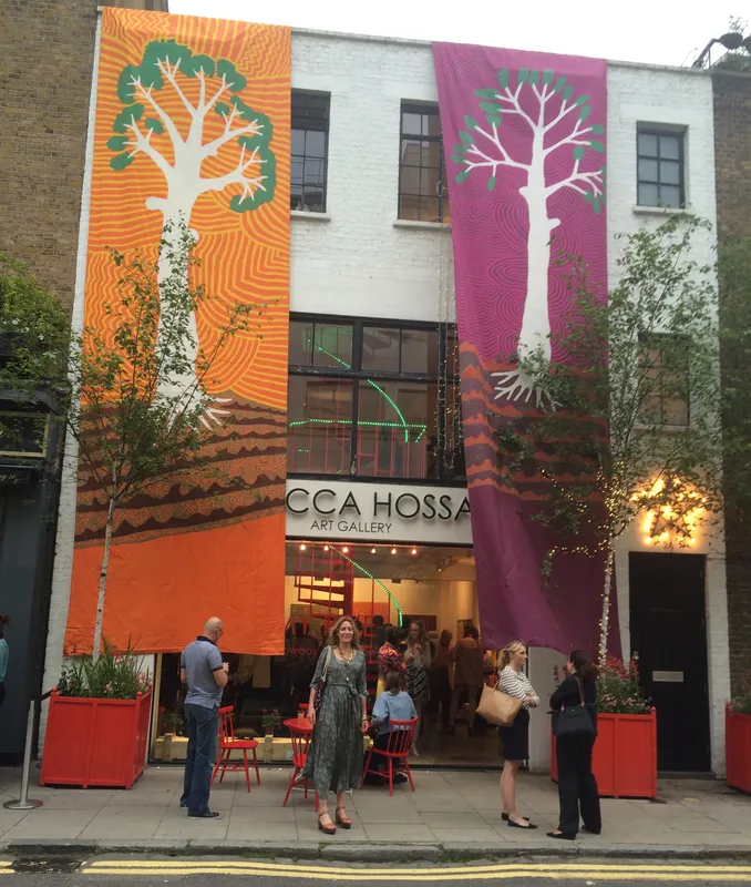 Rebecca Hossack outside the gallery with Jimmy Pike's banners