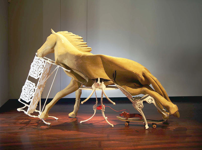 Lou Hubbard, Dead Still Standing, 2015, Rubber horse, polystyrene, Coalbrookdale outdoor furniture, acrylic dog & leash, skateboard