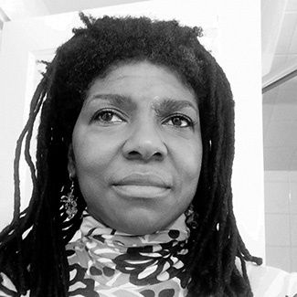 Black and white photograph closeup photograph of a woman with braided hair pushed back. 