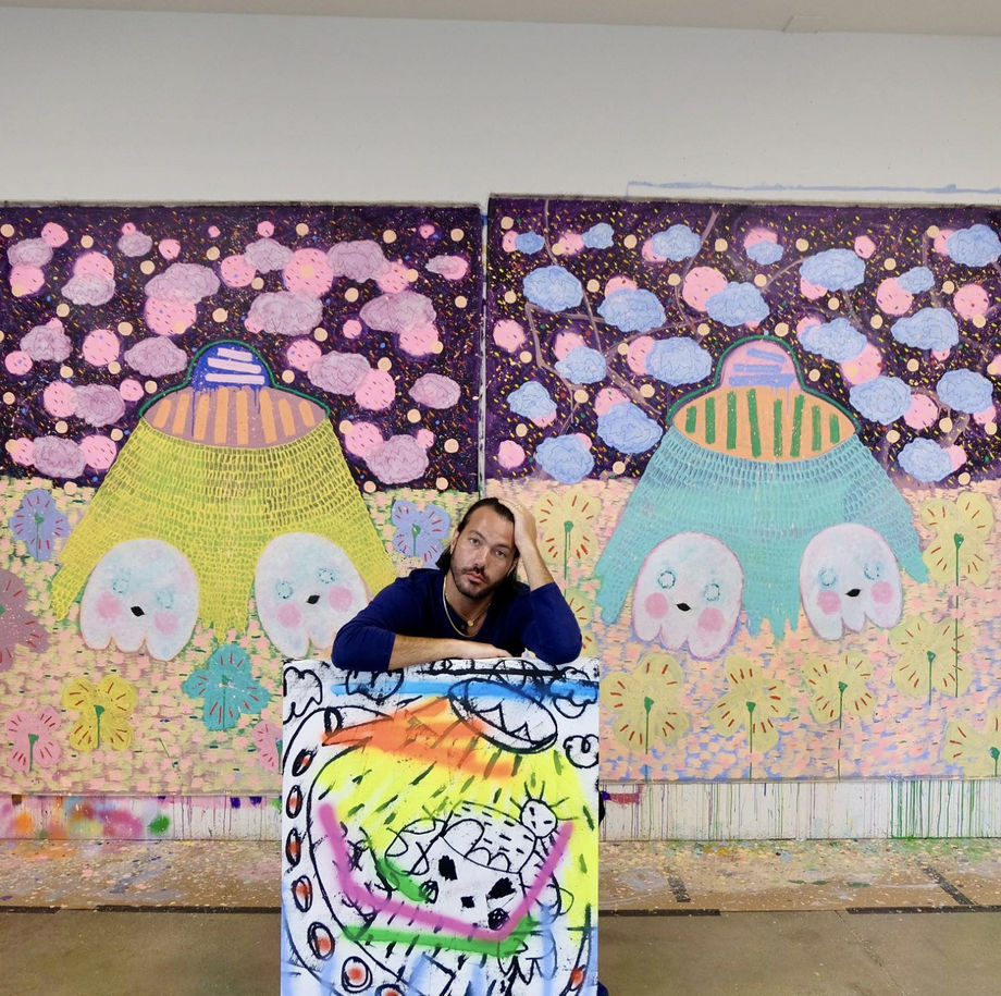 Artist Adam Handler in the studio with original paintings