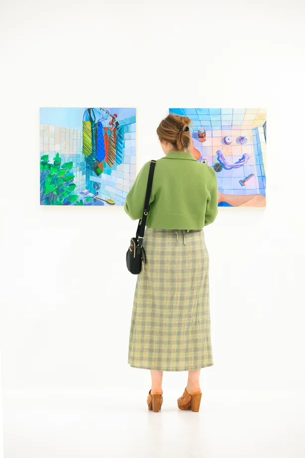 Guest with two paintings at "Lemons to Olives" by Erika Lee Sears